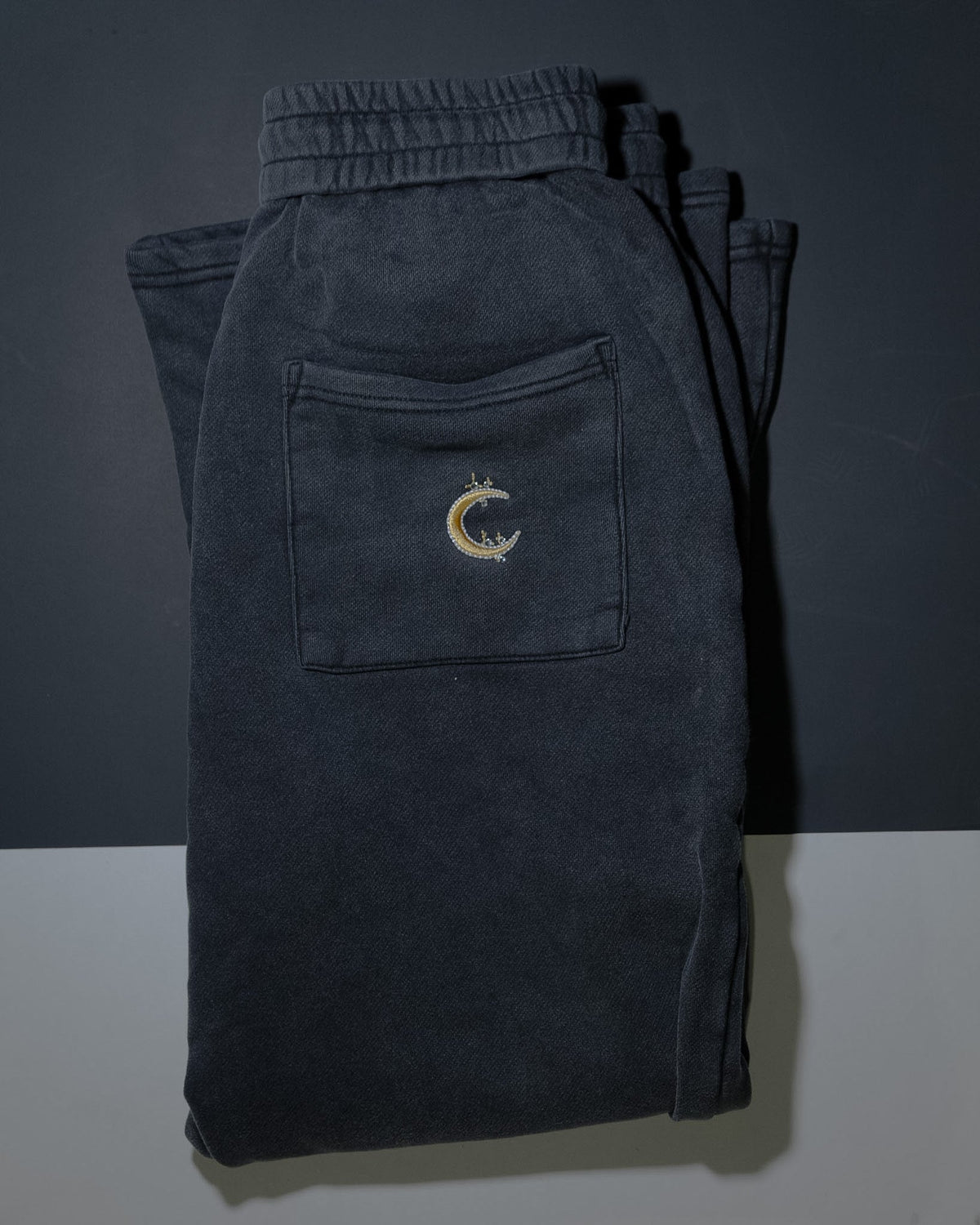 The Dawn flared sweatpant folded, gold crescent embroidery on the back pocket