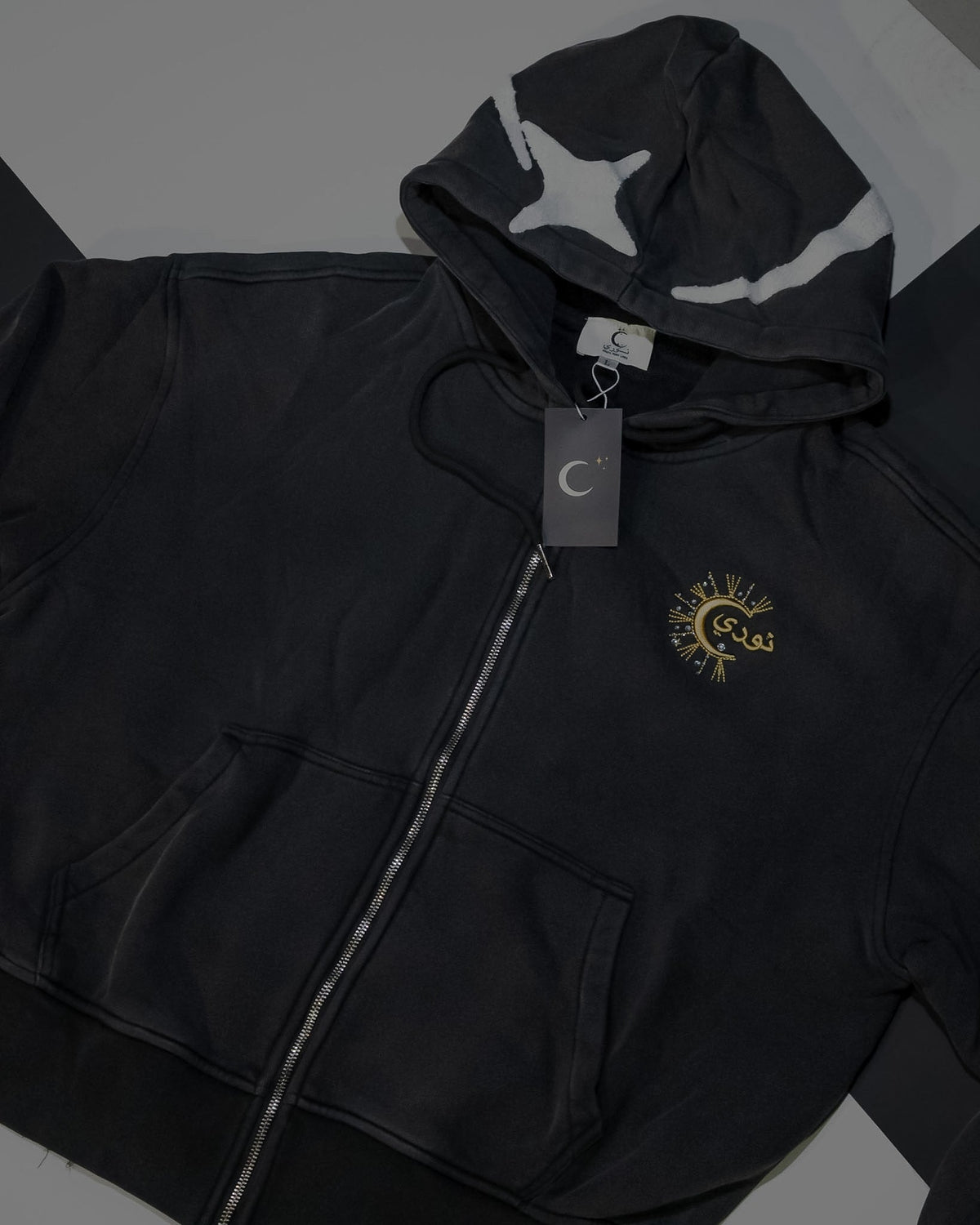 The Dawn zip-up hoodie with its hang tag, hood star and full-length zip